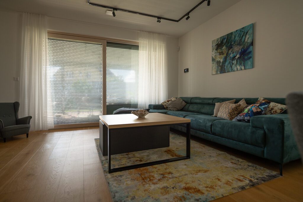 Stažená venkovní roleta brání přehřívání i únikům tepla - pohled z obývacího pokoje