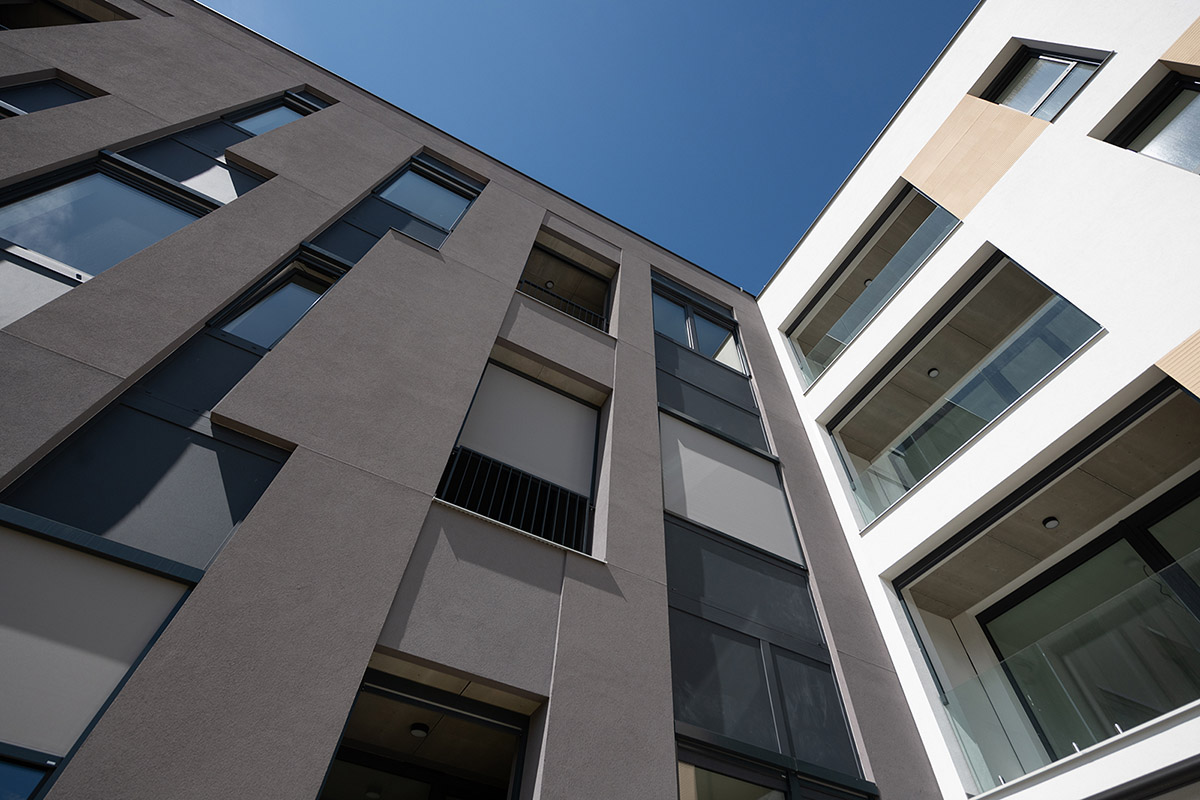 Moderní bytový dům se screenovými roletami proti větru CLIMAX – odolné stínění pro vysoké fasády.