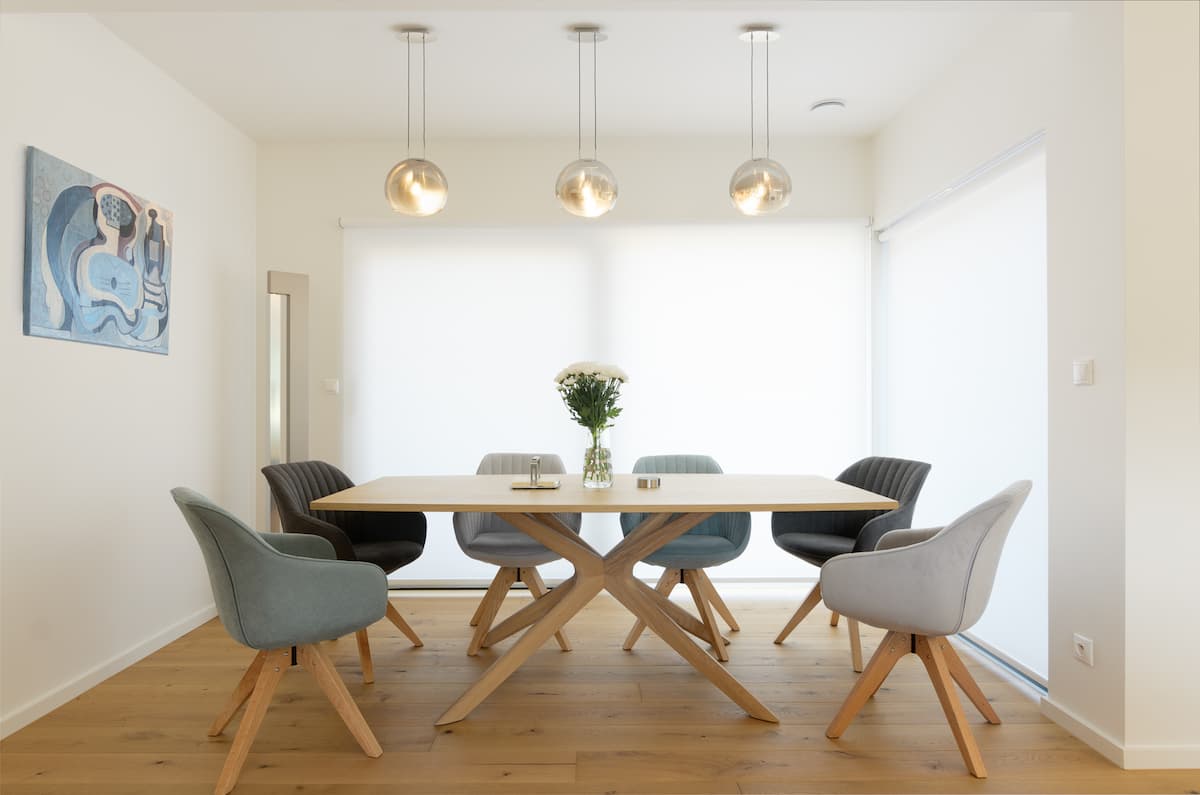 Moderní jídelna s interiérovými screenovými roletami, které zjemňují denní světlo.