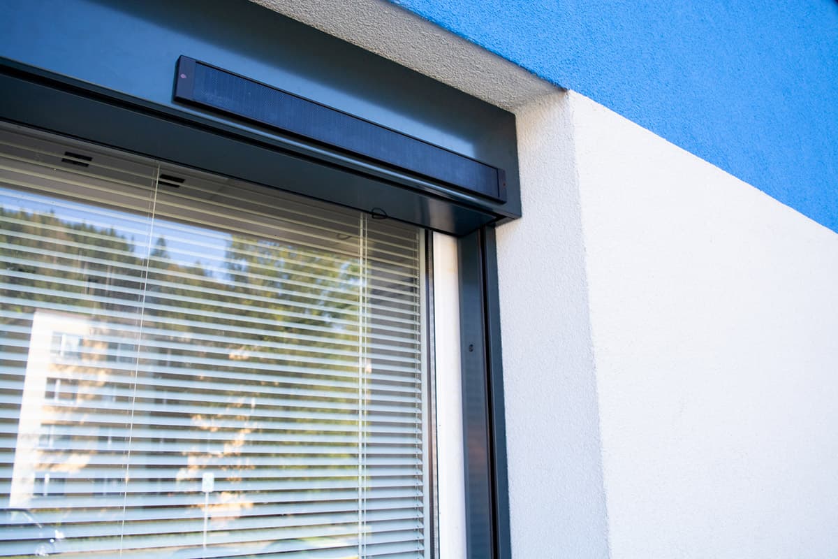 Dodatečná montáž venkovních žaluzií Comfort systém na fasádě domu.