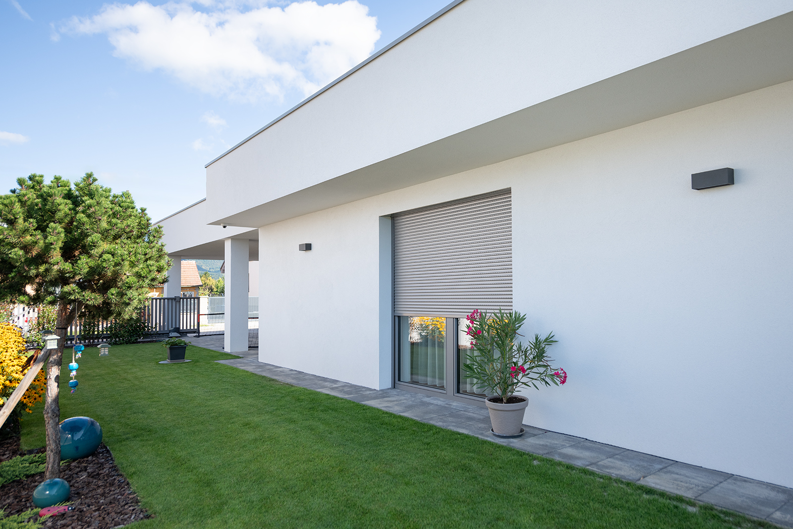 Moderní rodinný dům s venkovní hliníkovou roletou na okně – ukázka, co je hliníková roleta v praxi.