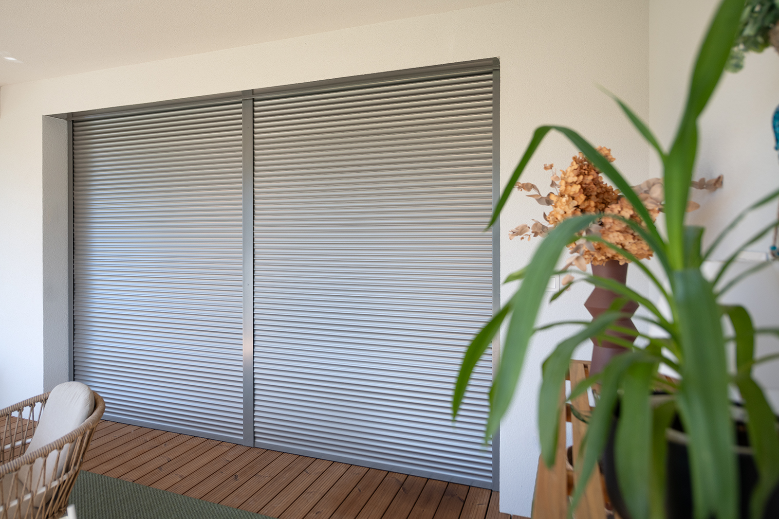 Detail stažené hliníkové rolety s vodicími lištami na terase rodinného domu.