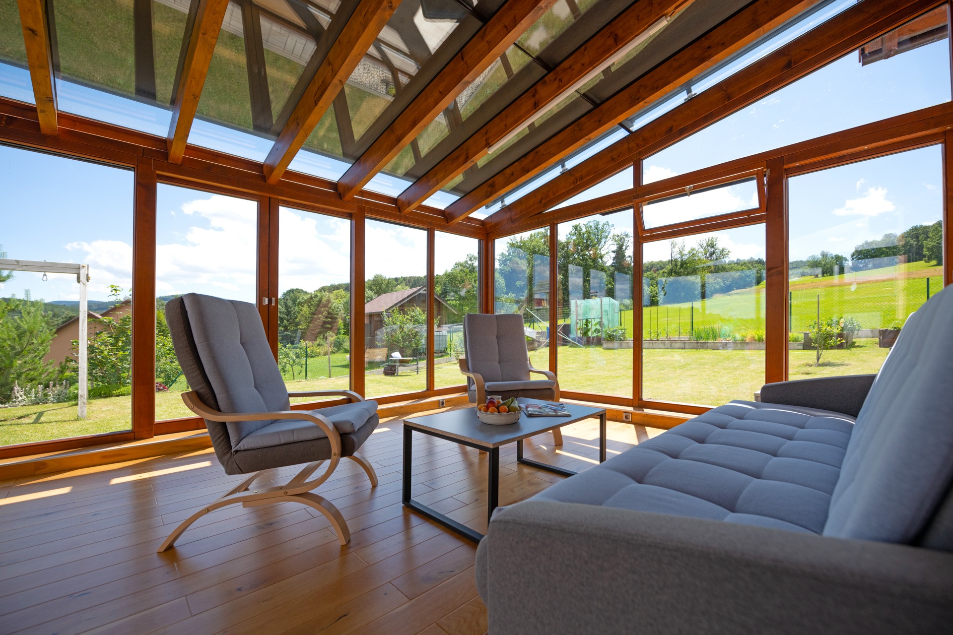 Prosklená zimní zahrada s posezením zastíněná stíněním zimních zahrad