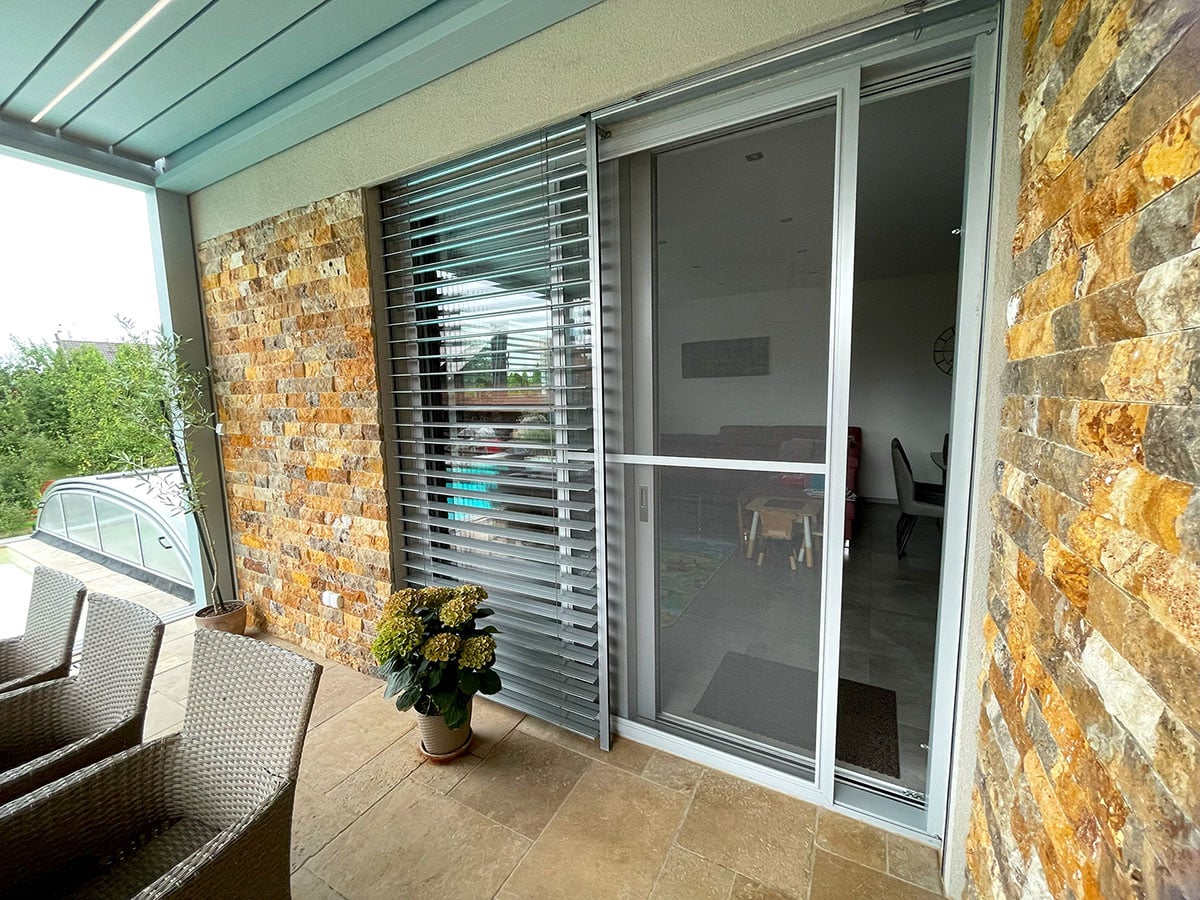 Posuvní síť s venkovními žaluziemi v šedé barvě na terase s dekorem